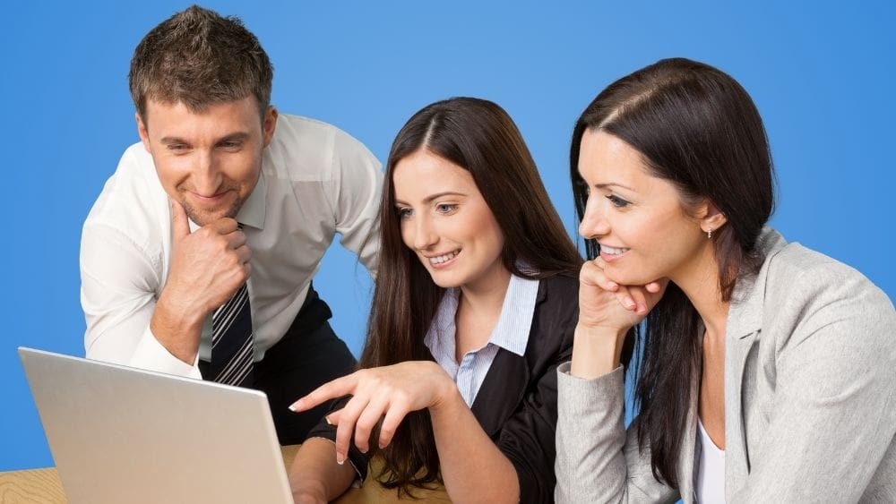 How to Align PPC with Your Sales Team - Team looking at laptop